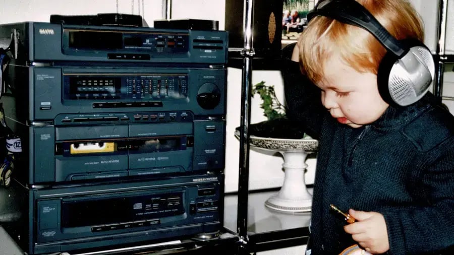 Kinderbild von Jonas von SmartIT vor einer Musikanlage mit Kopfhörern auf